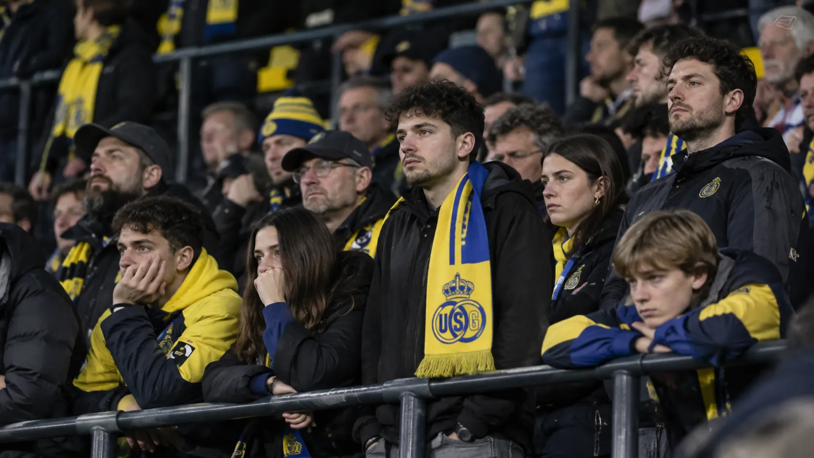 Supporters van Union met geel-blauwe sjaals op de tribune na de thuiswedstrijd tegen OHL.