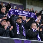 Een groep Patro Eisden-supporters viert samen in de tribune na de derbyzege.