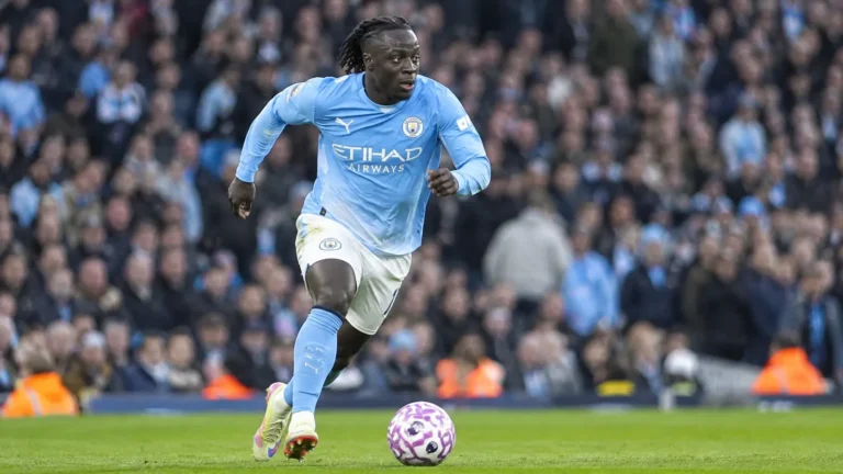 Jérémy Doku dribbelt met de bal in het lichtblauwe shirt van Manchester City.