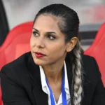 Ster Habibzadeh zit geconcentreerd op een rode stadionbank.