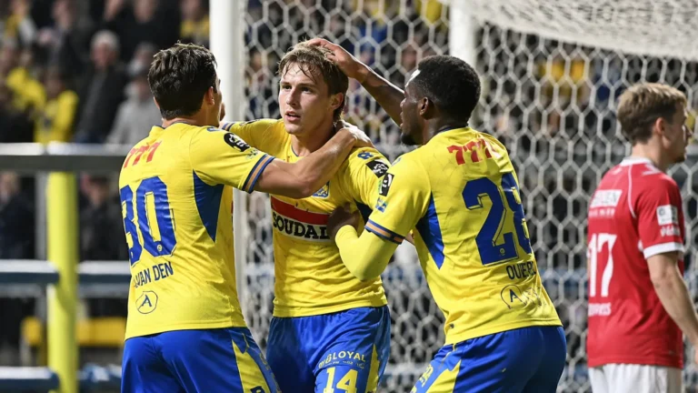 Een groep Westerlo-spelers viert een doelpunt vlak voor het doel.