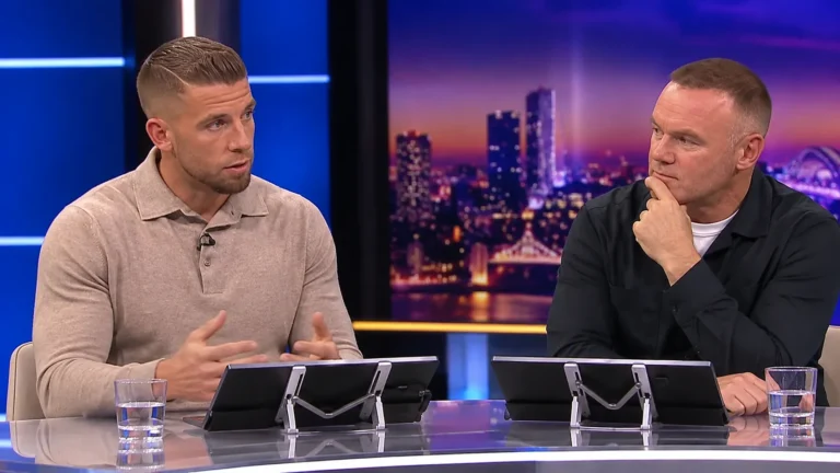 Twee voetbalanalisten aan een desk in een televisiestudio.