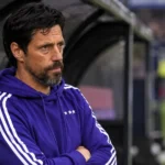 Een Anderlecht-coach kijkt geconcentreerd vanuit de dug-out naar het veld.