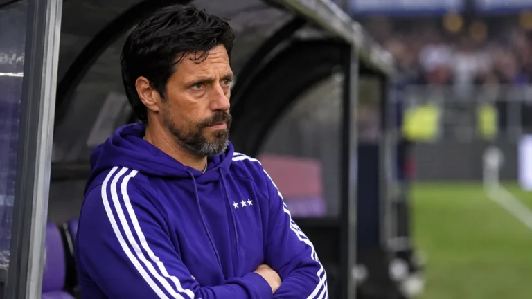 Een Anderlecht-coach kijkt geconcentreerd vanuit de dug-out naar het veld.