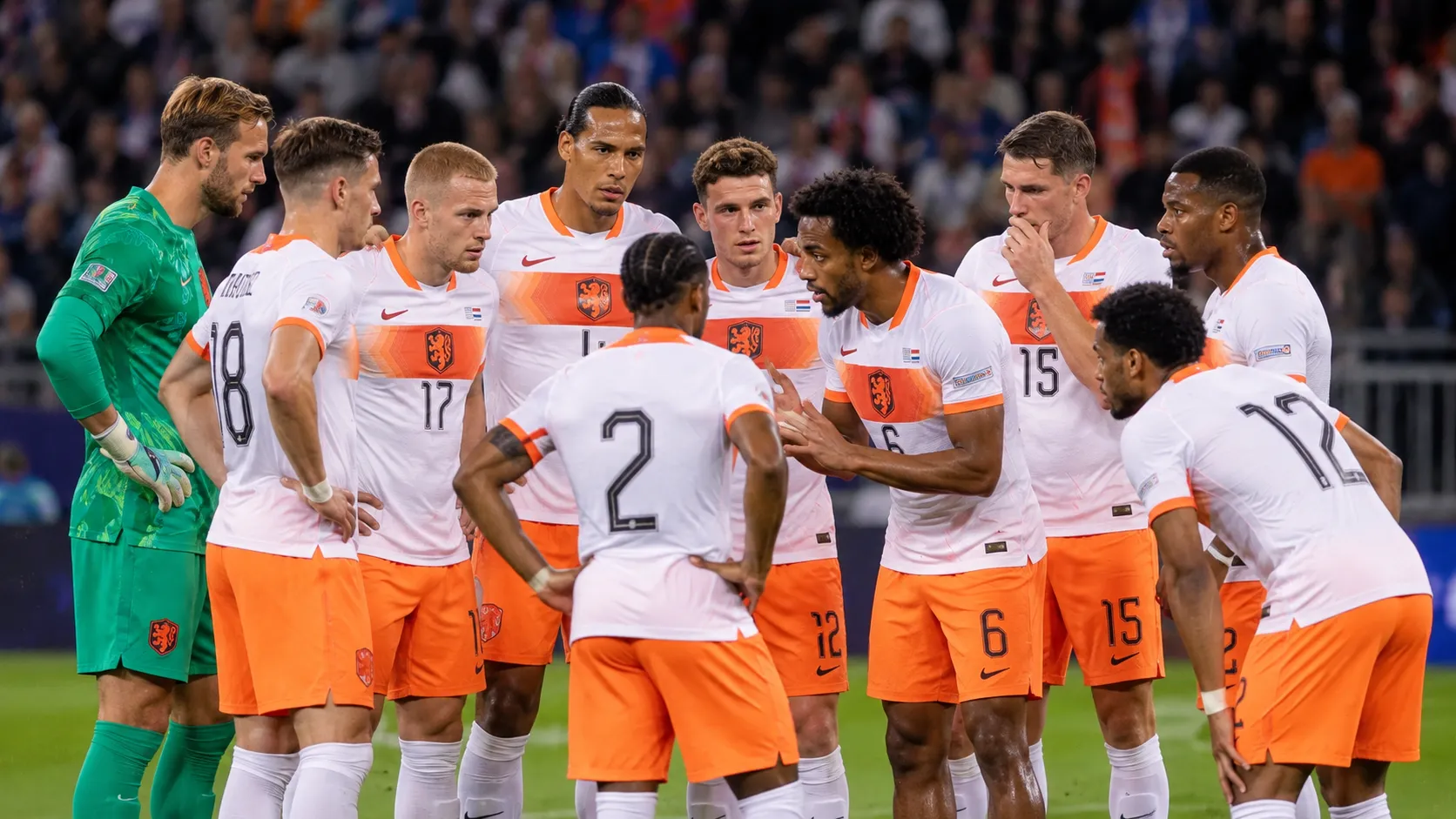 Nederlandse internationals verzamelen zich op het veld in witte en oranje tenues.
