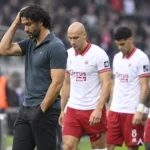 Marvin Compper staat na de wedstrijd langs de zijlijn terwijl Antwerp-spelers achter hem wachten.