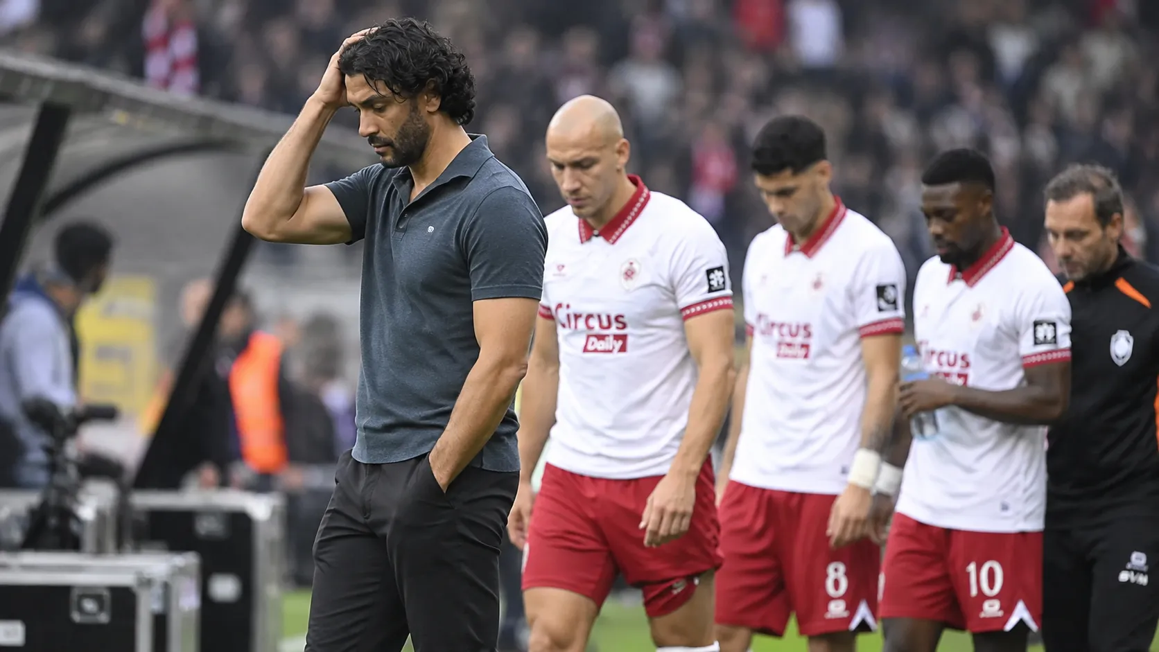 Marvin Compper staat na de wedstrijd langs de zijlijn terwijl Antwerp-spelers achter hem wachten.