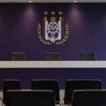 Lege mediaruimte van Anderlecht met een clubembleem op de vaste achterwand.