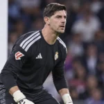 Thibaut Courtois in zwart Real Madrid-keeperstenue bij zijn doelgebied.