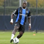 Een Club Brugge-speler in blauw-zwart tenue tijdens een opwarming op het veld.