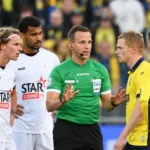 Een scheidsrechter spreekt met spelers van Union en OH Leuven tijdens een wedstrijdonderbreking.