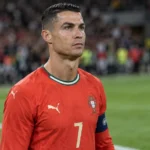 Cristiano Ronaldo in het Portugese nationale teamtenue aan de zijlijn van een stadion.