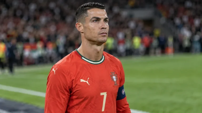 Cristiano Ronaldo in het Portugese nationale teamtenue aan de zijlijn van een stadion.