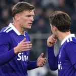 Anderlecht-spelers in blauwe wedstrijdtenues lopen samen op het veld.