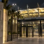 Lege verlichte stadiontoegang in Riyad met een Al Nassr-embleem op een vast metalen bord.