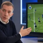 Jonathan Lardot tijdens een televisie-interview naast een scherm met een VAR-analyse van Club Brugge.