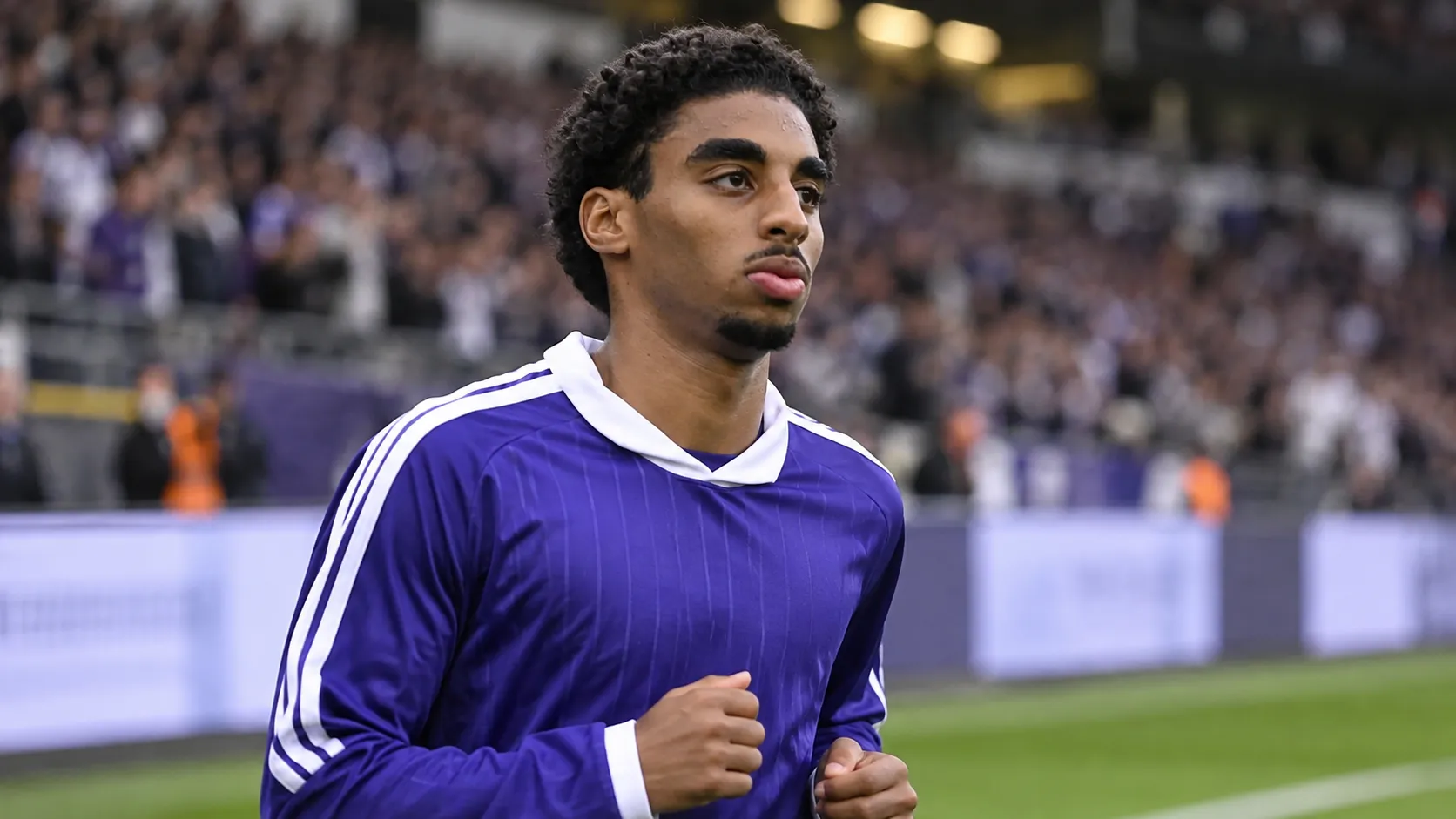 Kaïs Barry in paars-witte wedstrijdkleding tijdens een opwarming in het stadion.