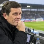Gert Verheyen kijkt voor de aftrap geconcentreerd vanuit de tribune naar het veld.
