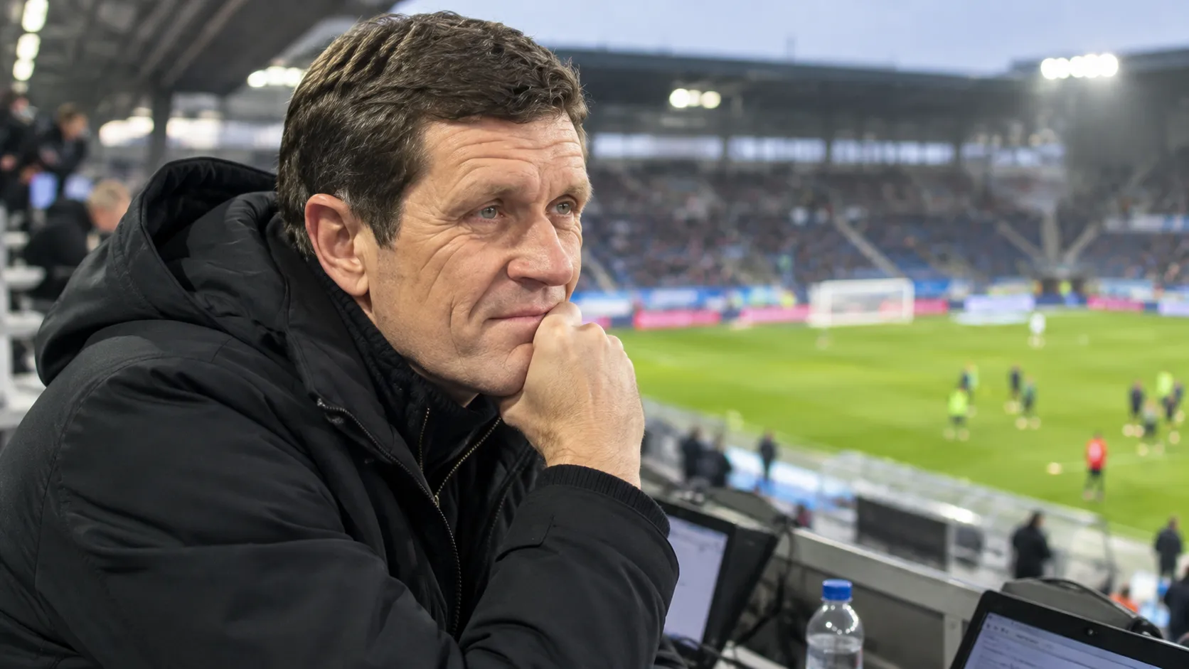 Gert Verheyen kijkt voor de aftrap geconcentreerd vanuit de tribune naar het veld.