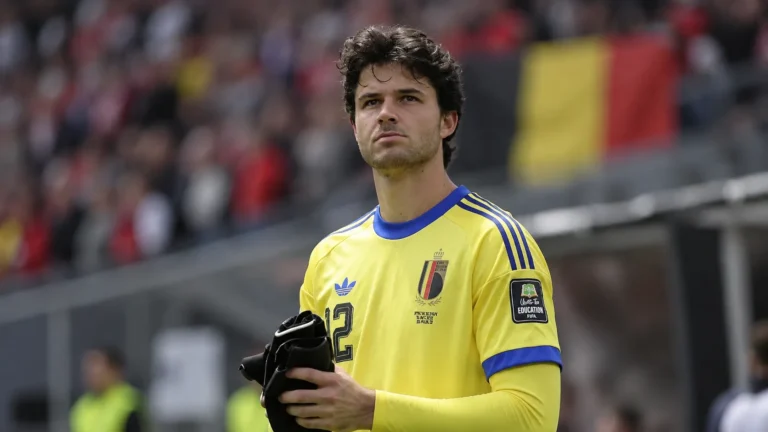 Senne Lammens in geel doelmanstenue op het voetbalveld.
