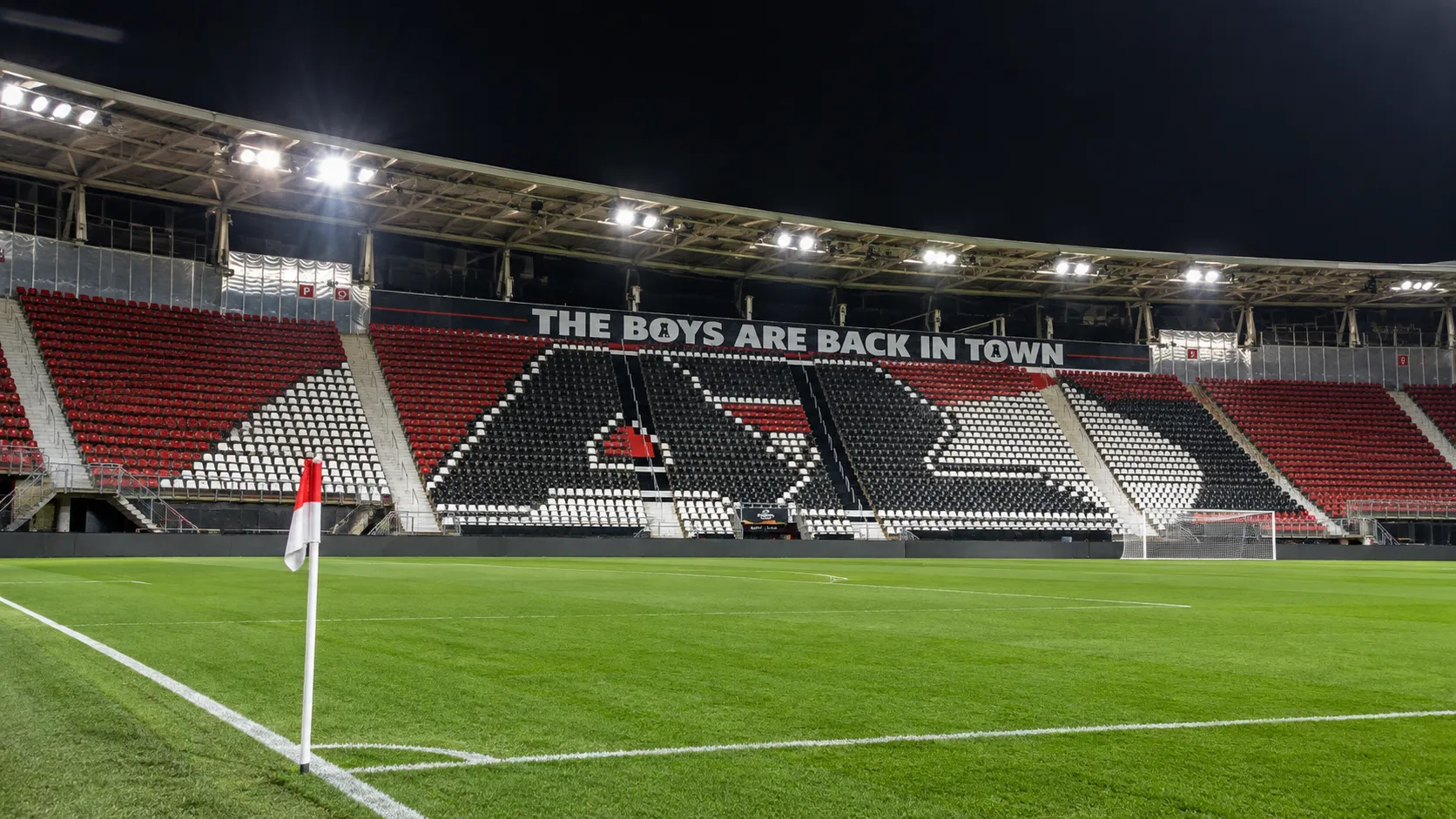 Lege tribune van het AZ-stadion met een rood-wit-zwart patroon in de zitplaatsen.
