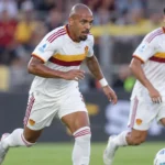 Donyell Malen in een wit AS Roma-tenue tijdens een wedstrijd.