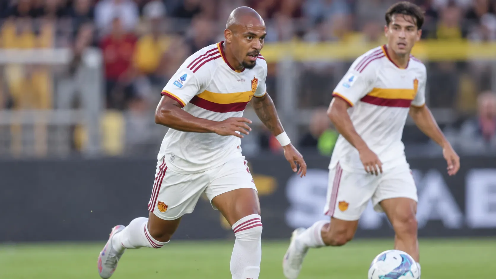 Donyell Malen in een wit AS Roma-tenue tijdens een wedstrijd.