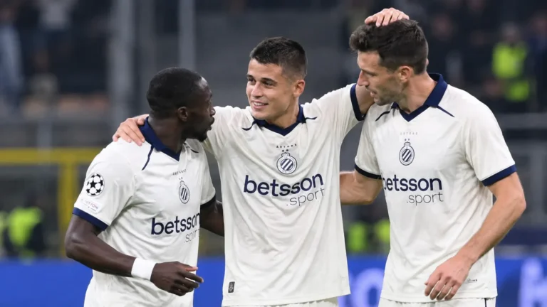 Drie spelers van Club Brugge juichen samen op het veld van San Siro.
