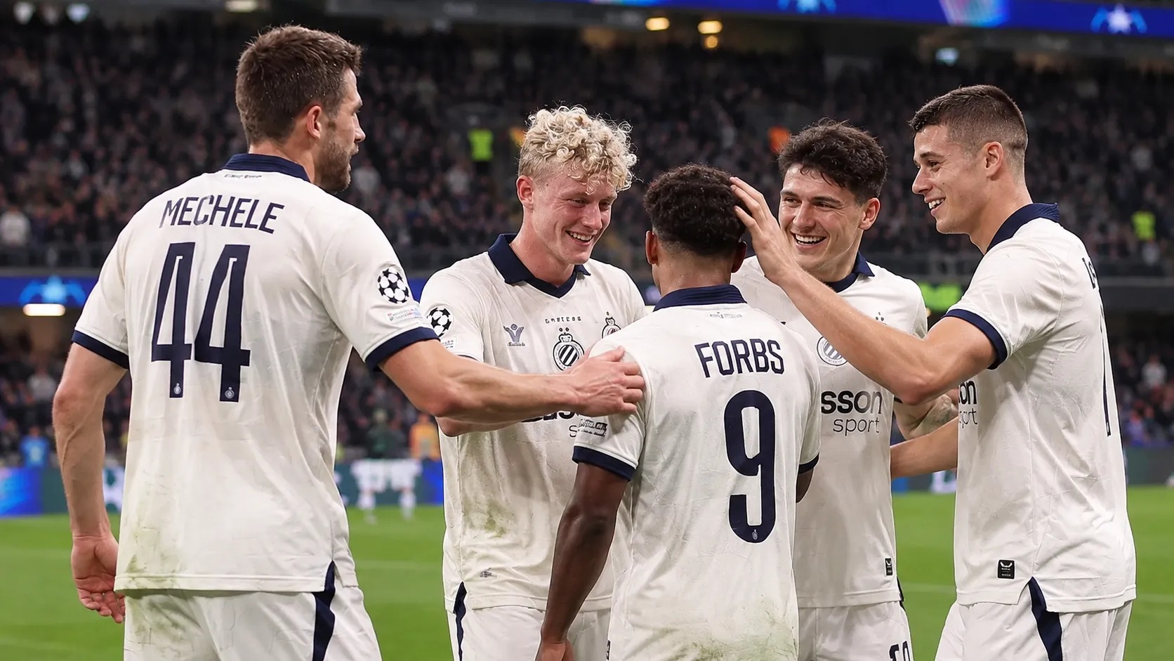 Een groep spelers van Club Brugge viert samen op het veld na de wedstrijd.