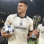 Nicolò Tresoldi van Club Brugge met een matchbal en trofee aan de rand van het veld.