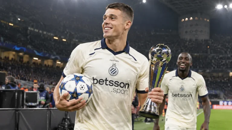 Nicolò Tresoldi van Club Brugge met een matchbal en trofee aan de rand van het veld.