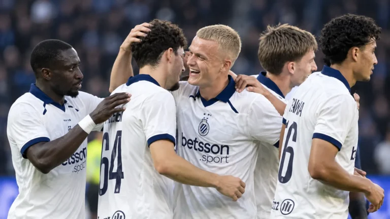Een groep Club Brugge-spelers viert samen op het veld na een Europese uitzege.