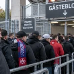 Een groep supporters van 1. FC Kaiserslautern verzamelt aan de ingang van het uitvak met blauw-rode sjaals.