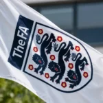 Een witte FA-vlag met het embleem van de Engelse voetbalbond aan een vlaggenmast.