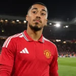 Een speler van Manchester United in een rood shirt op het veld na de wedstrijd.