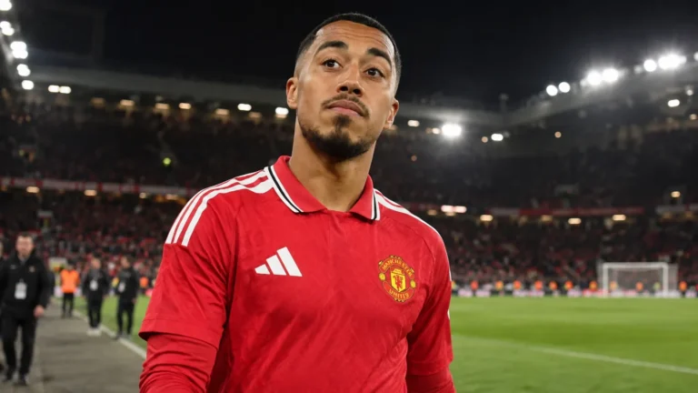 Een speler van Manchester United in een rood shirt op het veld na de wedstrijd.