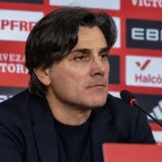 Vincenzo Montella spreekt op een persconferentie voor een rode sponsorwand.