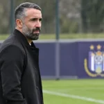 Jérémy Taravel kijkt aandachtig vanaf de zijlijn van een trainingsveld van Anderlecht.
