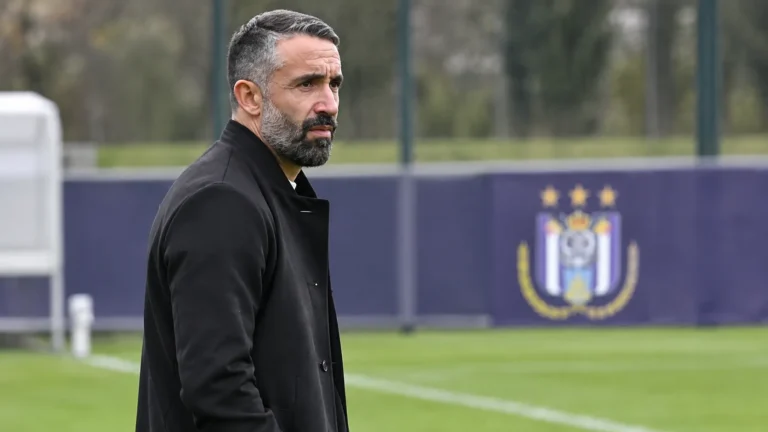 Jérémy Taravel kijkt aandachtig vanaf de zijlijn van een trainingsveld van Anderlecht.