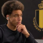 Axel Witsel tijdens een rustig interview in een neutrale mediaruimte met een Rode Duivels-embleem op een wandpaneel.