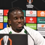 Massiré Sylla tijdens een persconferentie voor een Europa League-wedstrijd.
