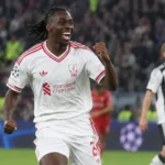 Een Liverpool-speler in wit wedstrijdtenue tijdens een Champions League-wedstrijd.
