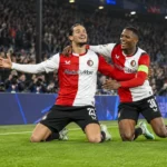 Twee Feyenoord-spelers vieren samen op het veld tijdens een Champions League-wedstrijd.